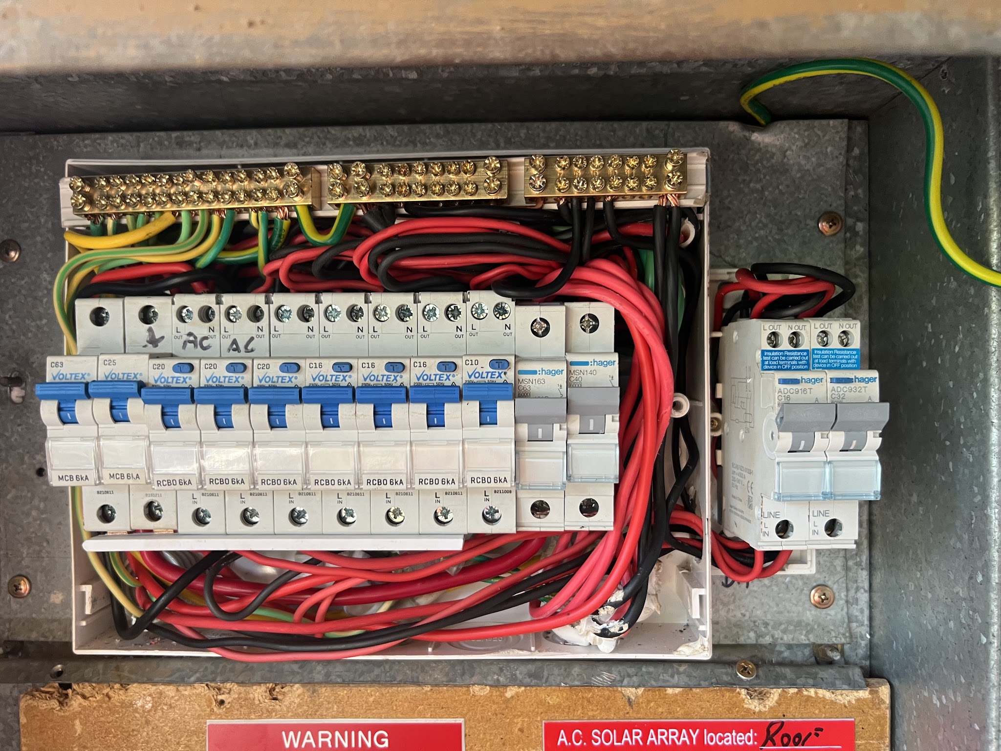 Rebuilt switchboard with RCBO banks, dressed wiring and a solar array warning label
